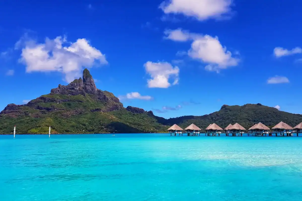 Bora Bora Travel Guide green mountain beside body of water under blue sky during daytime