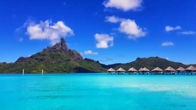 Bora Bora Travel Guide green mountain beside body of water under blue sky during daytime