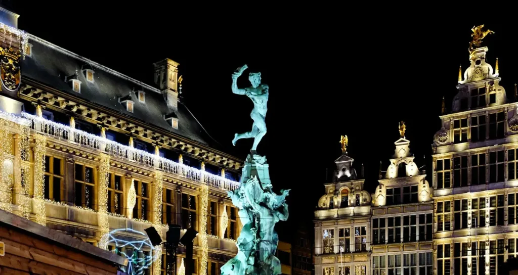 Antwerp Travel Guide white concrete building with statue during night time