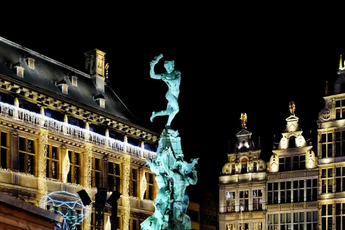 Antwerp Travel Guide white concrete building with statue during night time