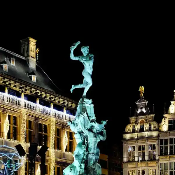 Antwerp Travel Guide white concrete building with statue during night time