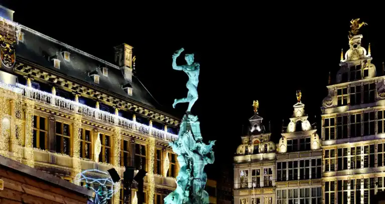 Antwerp Travel Guide white concrete building with statue during night time