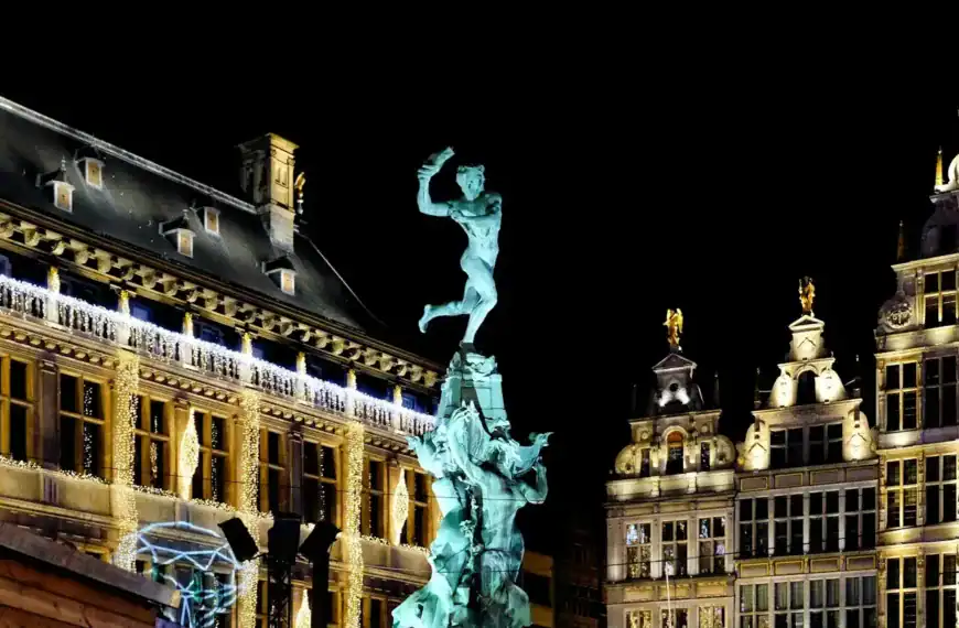 Antwerp Travel Guide white concrete building with statue during night time