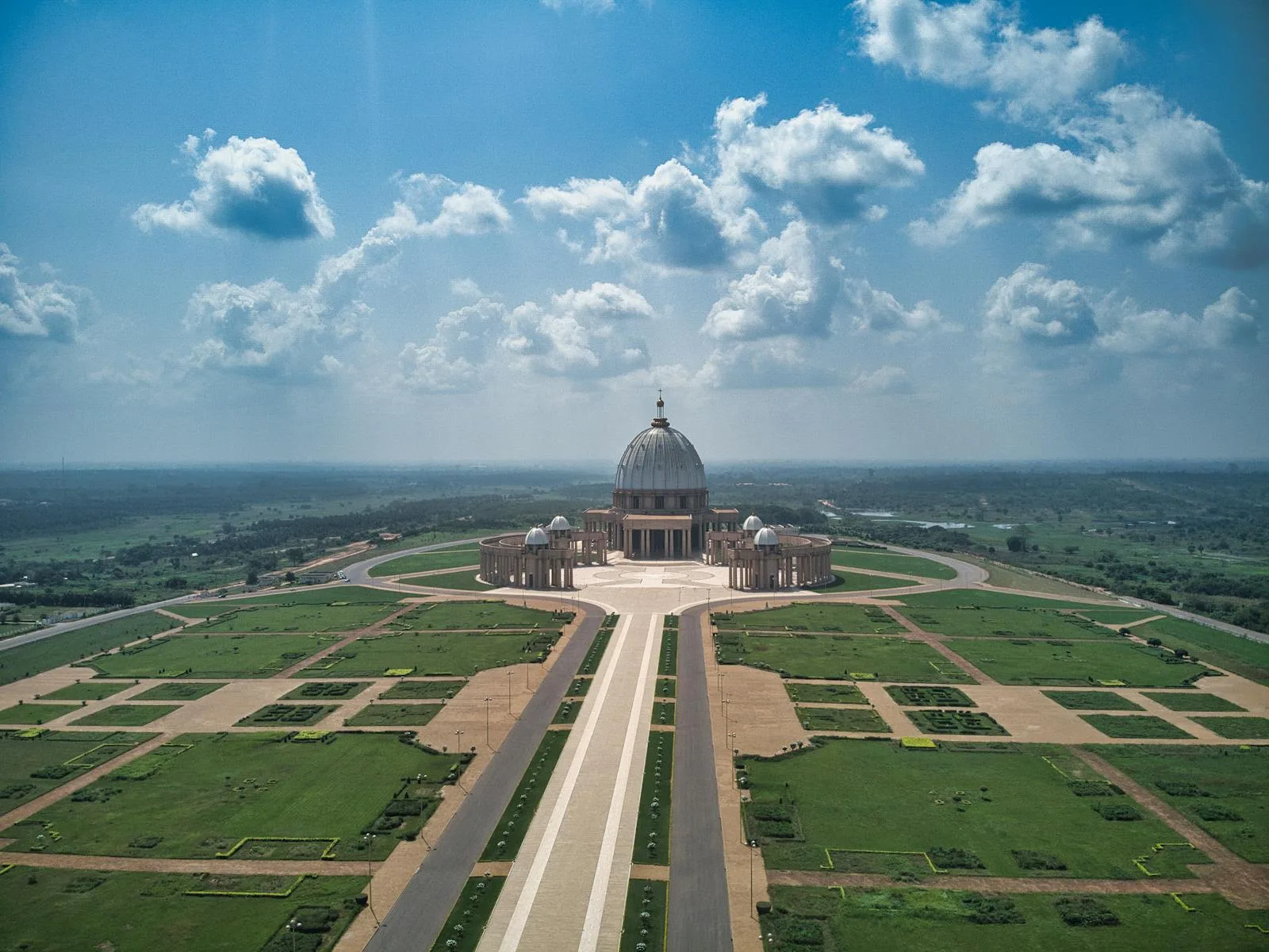 Côte d’Ivoire Travel Guide Aerial view of the Basilica of Our Lady of Peace in Yamoussoukro under a bright sky.