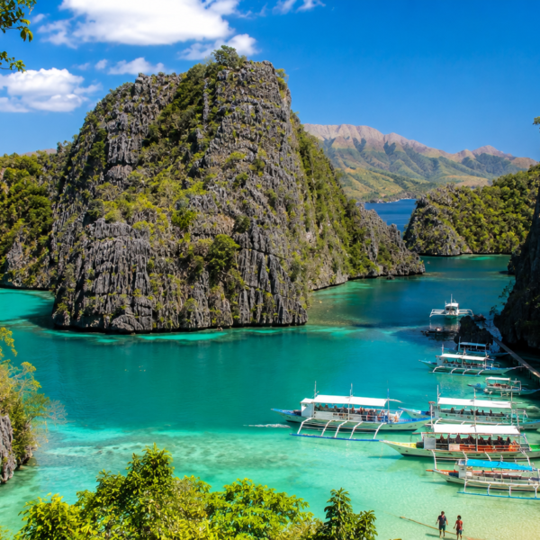 Palawan Travel Guide Tropical lagoon with boats and cliffs