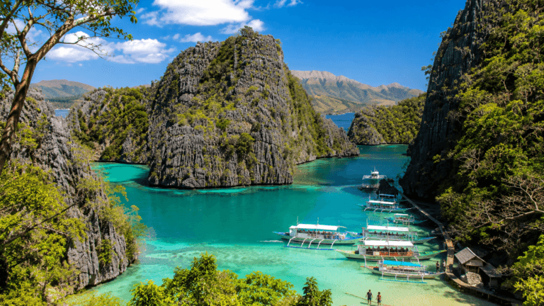 Palawan Travel Guide Tropical lagoon with boats and cliffs