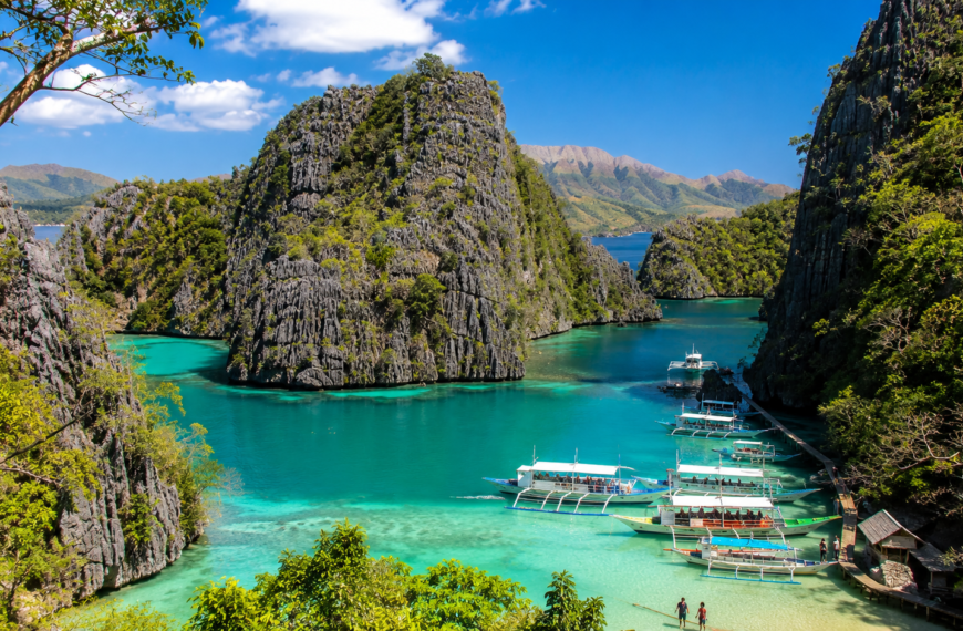 Palawan Travel Guide Tropical lagoon with boats and cliffs