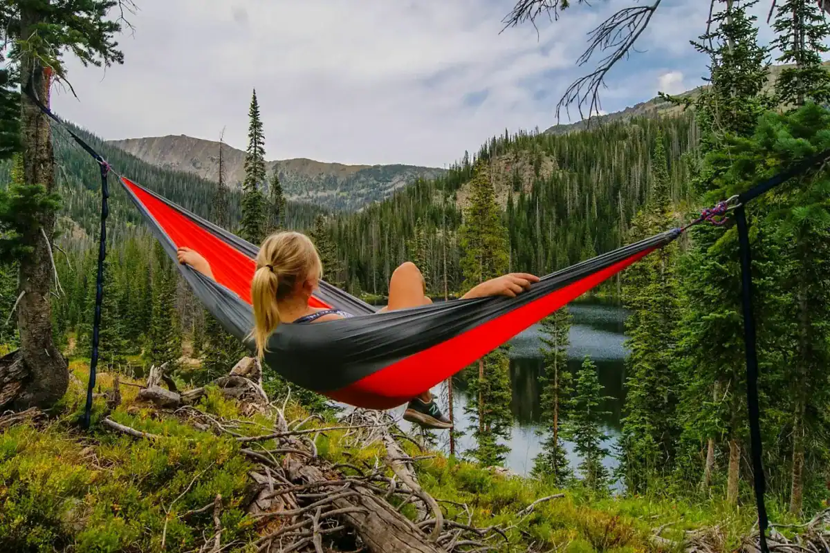 Travel Essentials Hub woman on hammock near to river