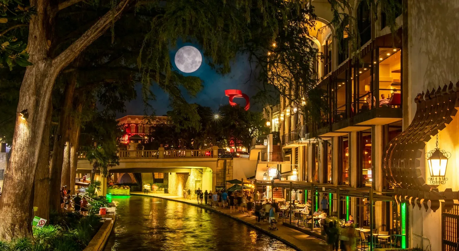 San Antonio Travel Guide a river running through a city at night