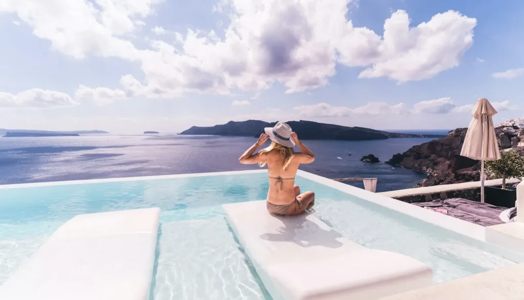 How to Travel Light woman sitting on white chair near body of water during daytime