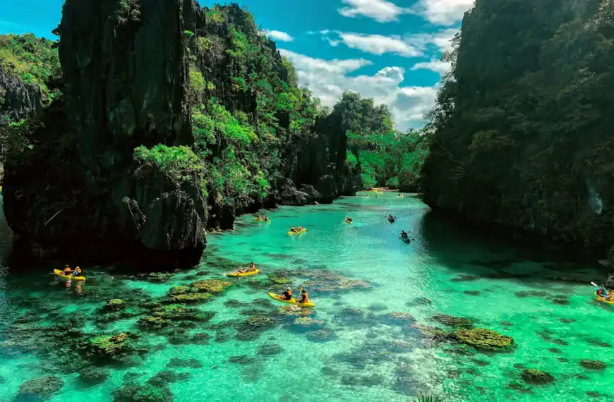 Palawan travel guide a group of people in a body of water surrounded by large rocks