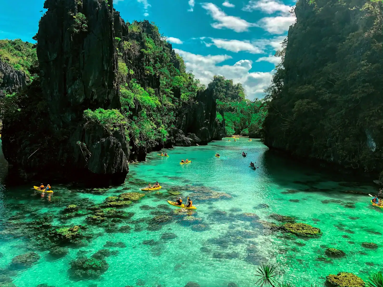 Palawan travel guide a group of people in a body of water surrounded by large rocks