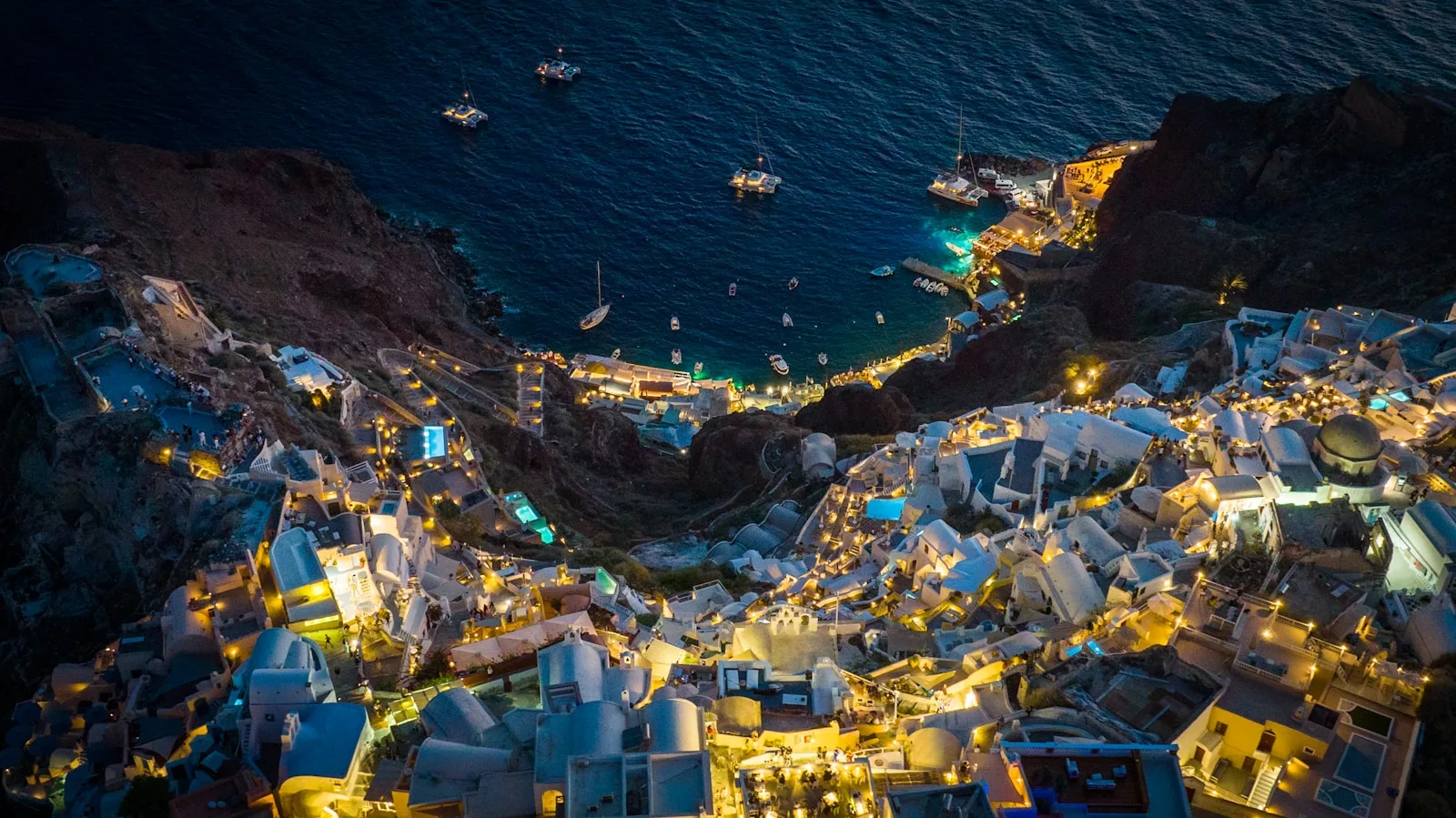 Santorini Travel Guide an aerial view of a city at night