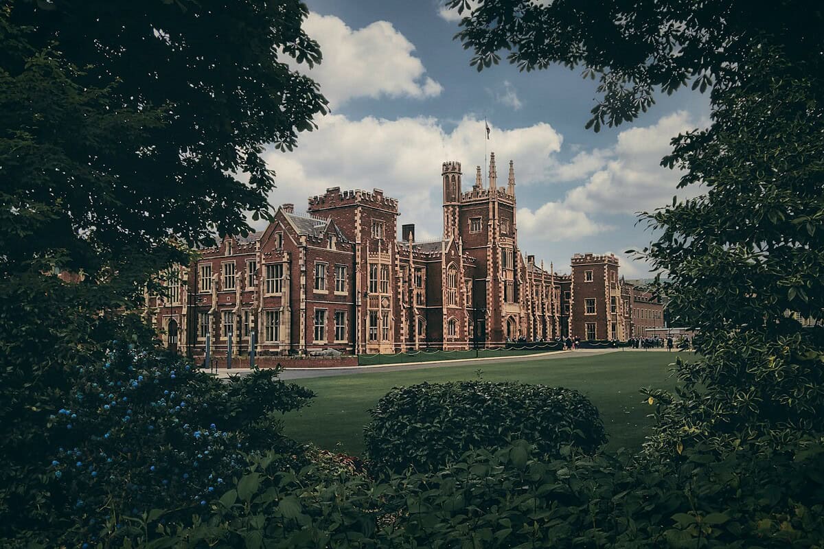 brown concrete building near green trees under blue sky during daytime