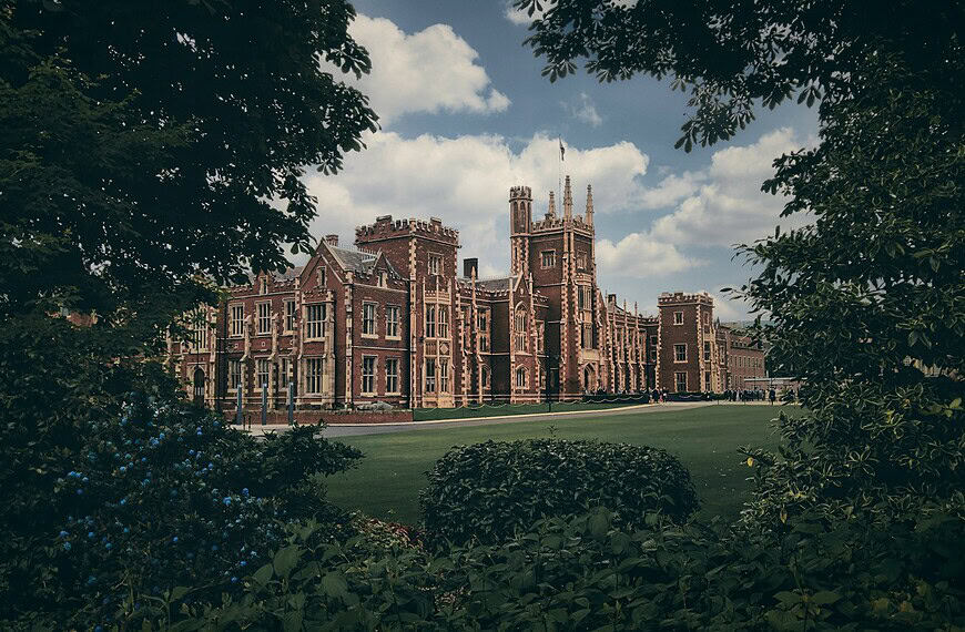 brown concrete building near green trees under blue sky during daytime
